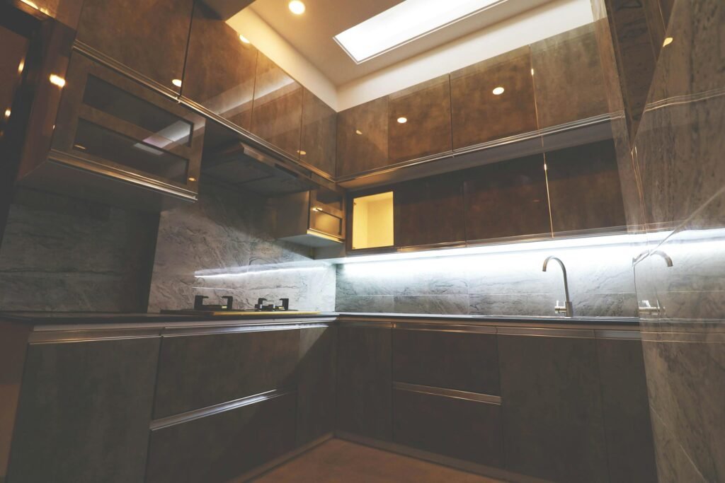 Stylish modern kitchen with sleek cabinets and ambient lighting, showcasing contemporary design.